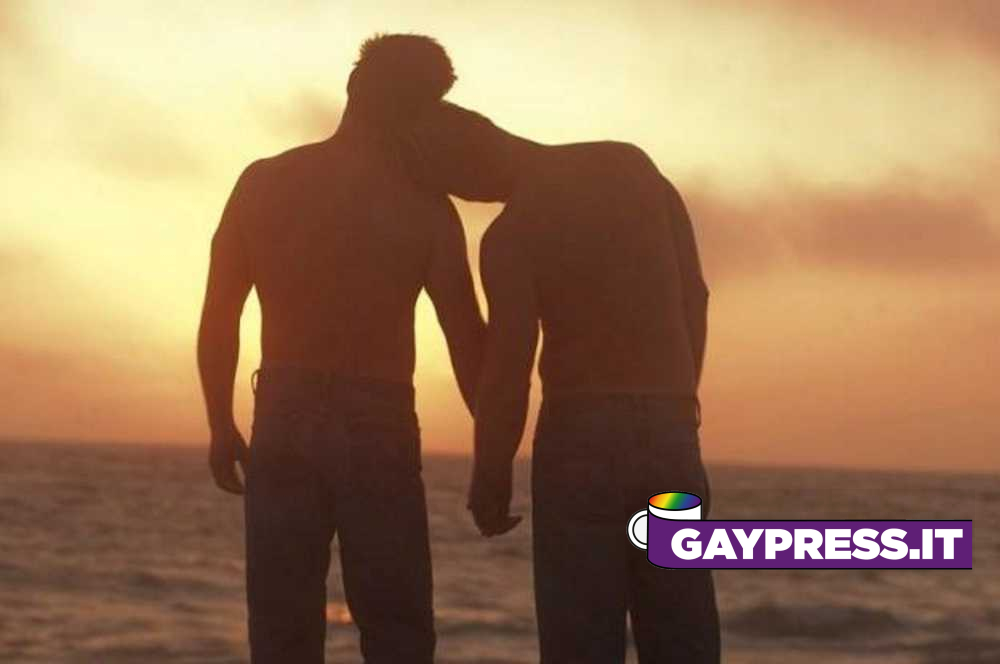 bacio gay in spiaggia cacciati dallo stabilimento: coppia gay uomini si tengono per mano al tramonto