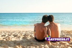 bacio gay in spiaggia: cacciati dallo stabilimento due uomini gay seduti in spiaggia amore