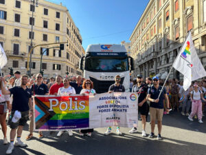 Forze dell'ordine di Polis Aperta al Roma Pride 2024 con carro sullo sfondo